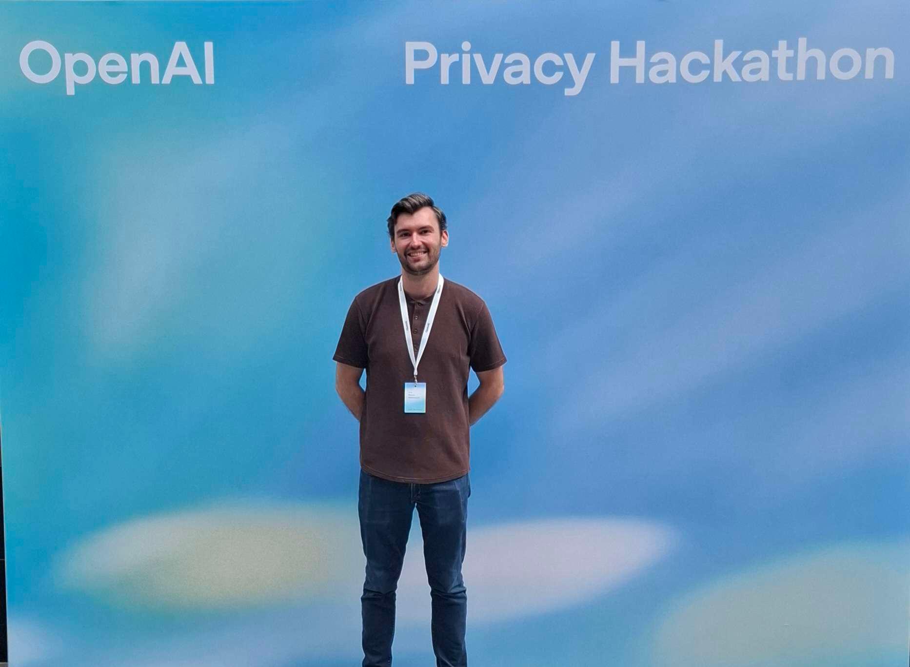 Portrait in front of the OpenAI Privacy Hackathon backdrop at Station F in Paris